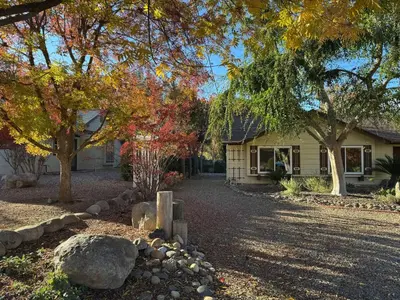 a house with a yard with trees and rocks at Magic Sequoia Spacious Home in Three Rivers