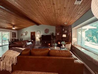 a living room with a brown couch and a living room with at Magic Sequoia Spacious Home in Three Rivers