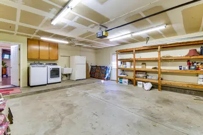 an empty room with a kitchen with appliances and shelves at Game Room and Bar Wooded Pine Mountain Lake Retreat in Groveland