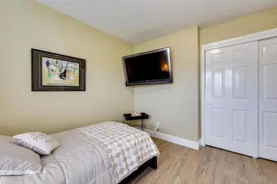 a bedroom with a bed and a flat screen tv on the wall at Golf, Hike, Explore Apt 9 Mi to Dtwn Fresno! in Fresno