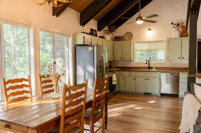 a kitchen with a wooden table and a refrigerator at Tallwood Cabin A Treetop Mountain Retreat in Shaver Lake
