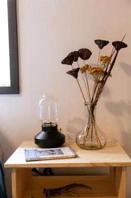 a table with a vase with dried flowers and a lamp at Tallwood Cabin A Treetop Mountain Retreat in Shaver Lake