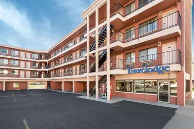 a large apartment building with a staircase in a parking lot at Travelodge by Wyndham Reno in Reno