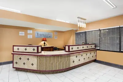 a hotel lobby with a waiting area with a traveler sign at Travelodge by Wyndham Reno in Reno