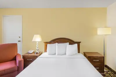 a hotel room with a bed and a chair at Travelodge by Wyndham Reno in Reno