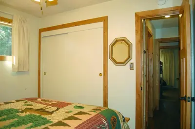 a bedroom with a bed and a mirror on the wall at Ox Yoke in Wawona