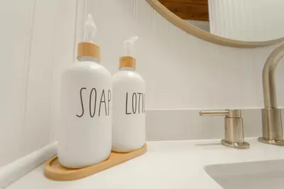 two white bottles on a wooden holder on a bathroom counter at Sequoia Vintage A-frame River Retreat in Three Rivers