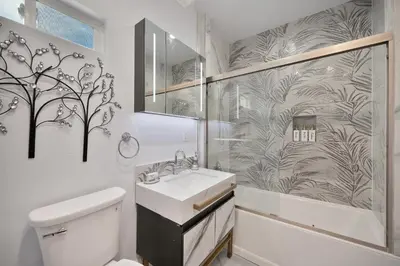 a white bathroom with a sink and a shower at Walk to UC Davis Medical Center! Duplex with Patio in Sacramento