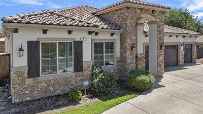 a house with a stone facade and a driveway at The Executive Retreat at Westberry in Madera