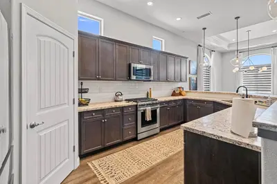 a kitchen with wooden cabinets and a white door at The Executive Retreat at Westberry in Madera