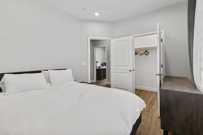 a bedroom with a white bed and a door at The Executive Retreat at Westberry in Madera