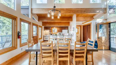 a dining room with a wooden table and chairs at Sleeps 20 2 Homes Near Ski Resort Beach Lake Access Pool Homewood in Tahoma