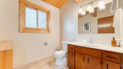a bathroom with a sink and a toilet and a mirror at Sleeps 20 2 Homes Near Ski Resort Beach Lake Access Pool Homewood in Tahoma