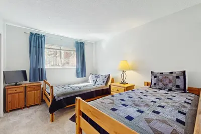 a bedroom with a bed and a couch and a tv at Glenwood Getaway in South Lake Tahoe