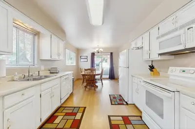 a kitchen with white cabinets and a table and chairs at Glenwood Getaway in South Lake Tahoe