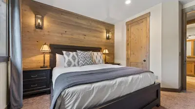 a bedroom with a large bed and a wooden wall at South Lake Escape Indoor Pool plus Movie Theater in South Lake Tahoe