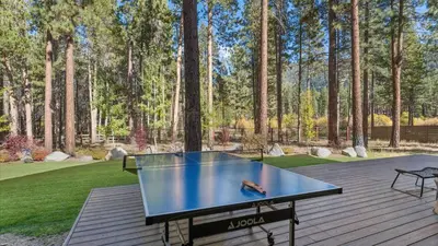 a ping pong table on a wooden deck with trees at South Lake Escape Indoor Pool plus Movie Theater in South Lake Tahoe
