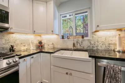 a white kitchen with a sink and a window at Private Woods - Cottage for 4 in South Lake Tahoe