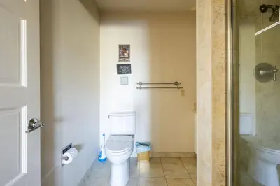 a small bathroom with a toilet and a shower at Grand Wine Country 6BR Retreat Hot Tub & Views in San Martin