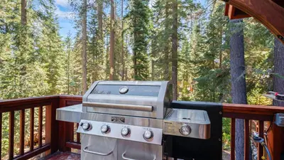 a grill on a deck on a porch with trees at Outdoor Dining Backyard Trails Nearby Cedar Hollow Retreat by AvantStay in Tahoma