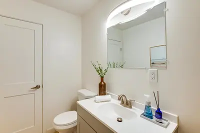 a white bathroom with a sink and a mirror at Hot Tub and Game Room Luxe Cabin, Day Trip to Tahoe in Pollock Pines
