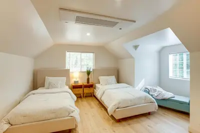 two beds in a room with two windows at Hot Tub and Game Room Luxe Cabin, Day Trip to Tahoe in Pollock Pines