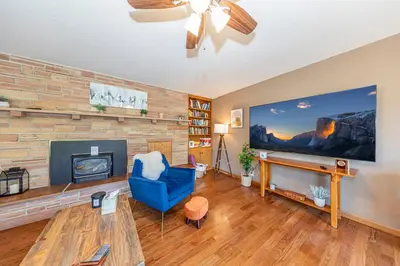 a living room with a blue chair and a fireplace at Sierra View Retreat with Newly Installed Hot tub! in Oakhurst