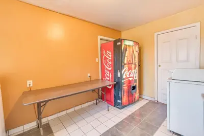 a kitchen with a bench and a soda machine at Los Banos Motel in Los Banos