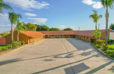 an empty parking lot in front of a building at Los Banos Motel in Los Banos