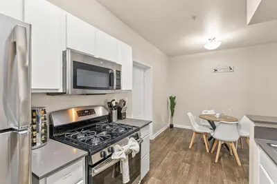 a kitchen with a stove top oven next to a table at Luxury King Suite by the Lake - Entire Place in Sparks