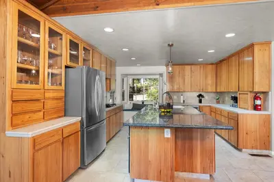 a kitchen with wooden cabinets and a stainless steel refrigerator at WoodUStau in Coarsegold