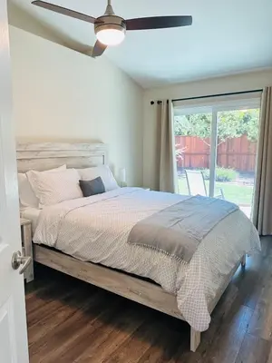 a bedroom with a bed and a ceiling fan at Contemporary, newly renovated and great location in Fresno