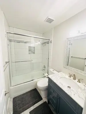 a bathroom with a shower and a toilet and a sink at Contemporary, newly renovated and great location in Fresno