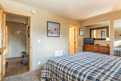 a bedroom with a bed and a tv at Updated1849 Townhome #611, Steps to Canyon Lodge 4 Bed/3BA, hot tubs, game rm, sauna! in Mammoth Lakes