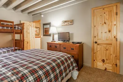 a bedroom with a bed and a tv on a dresser at Updated1849 Townhome #611, Steps to Canyon Lodge 4 Bed/3BA, hot tubs, game rm, sauna! in Mammoth Lakes