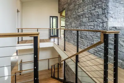 a staircase in a house with a stone wall at New Luxury Free Standing 4BR 4 and a halfBA Home Obsidian Reserve #146 Priv Hot Tub, 2-Car Garage Great Views in Mammoth Lakes