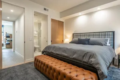 a bedroom with a large bed and a brown leather bench at New Luxury Free Standing 4BR 4 and a halfBA Home Obsidian Reserve #146 Priv Hot Tub, 2-Car Garage Great Views in Mammoth Lakes