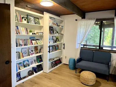 a room with book shelves with a chair and a window at Lakeview Yosemite 3B2b Private House - Panoramic Sauna - Seasonal Hot Tub Jacuzzi in Groveland