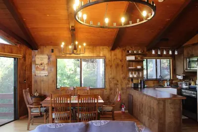 a kitchen and dining room with a table and chairs at Lakeview Yosemite 3B2b Private House - Panoramic Sauna - Seasonal Hot Tub Jacuzzi in Groveland