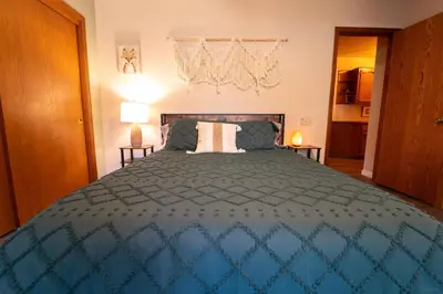 a bedroom with a bed with a blue comforter at Magic Sequoia Spacious Home in Three Rivers