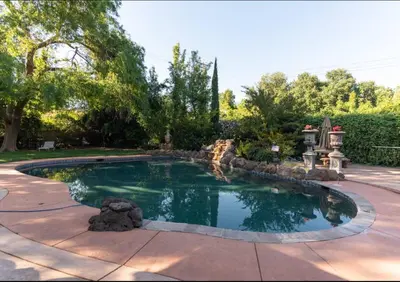 a swimming pool in a yard with a landscaping at Sac Camp Delta Garden Retreat in Sacramento
