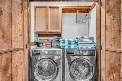 two washing machines in a small kitchen with cabinets at Kings Beach Retreat Hot Tub & Game Loft in Kings Beach