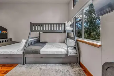 two bunk beds in a room with a window at Kings Beach Retreat Hot Tub & Game Loft in Kings Beach