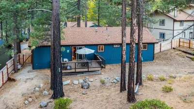 an aerial view of a blue house in the woods at Steps to Trails Minutes to Heavenly Fireplace Deck BBQ Bluewood Cabin by AvantStay in South Lake Tahoe