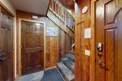 a wooden hallway with a wooden door and stairs at Chateau Sans Nom 12 in Mammoth Lakes