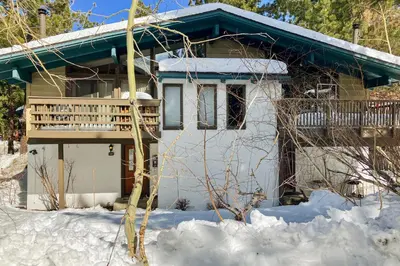 a house with a deck in the snow at Chateau Sans Nom 9 in Mammoth Lakes