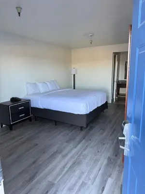 a bedroom with a large bed and a night stand at Rancho Cordova Inn in Rancho Cordova