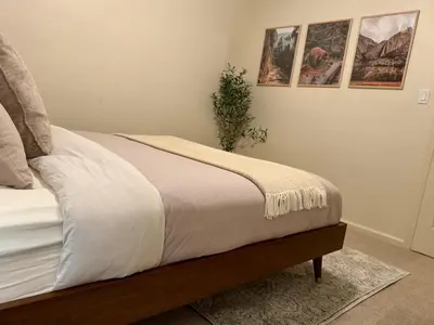 a bedroom with a bed with a white comforter at Relax Under the Stars, Best view in town , Yosemite House with Firepit, Hot Tub, Game Room & Pool table in Oakhurst