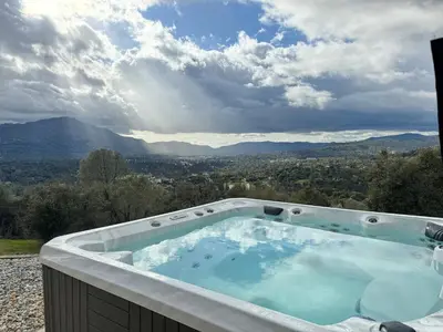 a hot tub with a view of the mountains at Relax Under the Stars, Best view in town , Yosemite House with Firepit, Hot Tub, Game Room & Pool table in Oakhurst