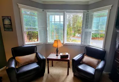 two chairs and a table in a room with windows at Country Style Mountain Home - View of Lake Forebay in Pollock Pines